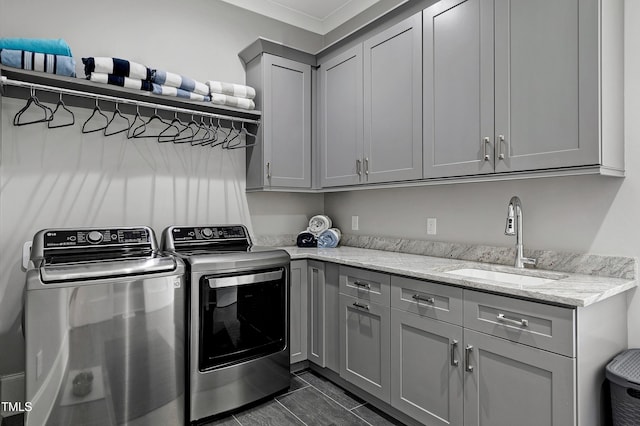 laundry room with independent washer and dryer, a sink, and cabinet space