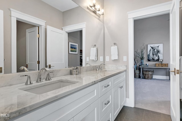 bathroom with tile patterned floors, a sink, baseboards, and double vanity