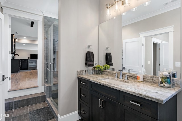 bathroom featuring a shower stall, visible vents, baseboards, and vanity