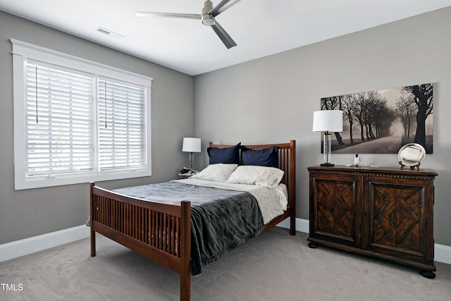 bedroom with a ceiling fan, light colored carpet, visible vents, and baseboards