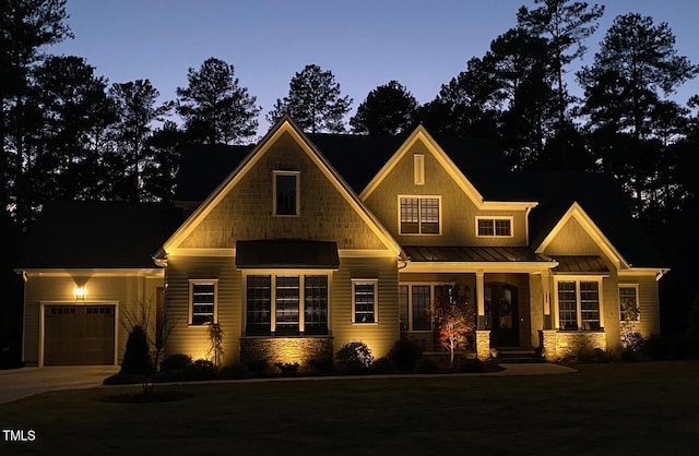 craftsman inspired home featuring a garage, a standing seam roof, metal roof, and concrete driveway