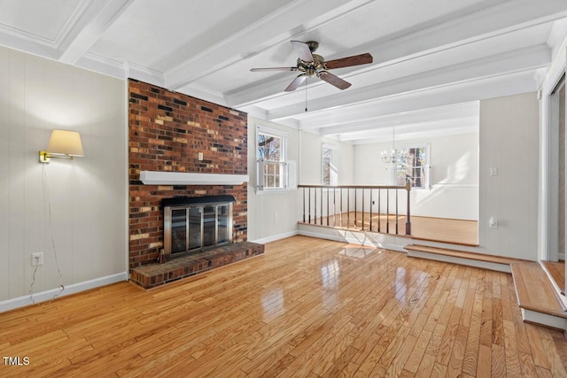 unfurnished living room featuring beam ceiling, baseboards, a fireplace, and wood finished floors