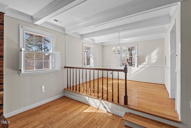 hall with visible vents, wood finished floors, beam ceiling, and an inviting chandelier