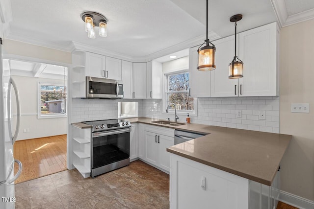 kitchen with dark countertops, appliances with stainless steel finishes, white cabinetry, open shelves, and a sink