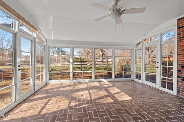 unfurnished sunroom featuring lofted ceiling and a ceiling fan