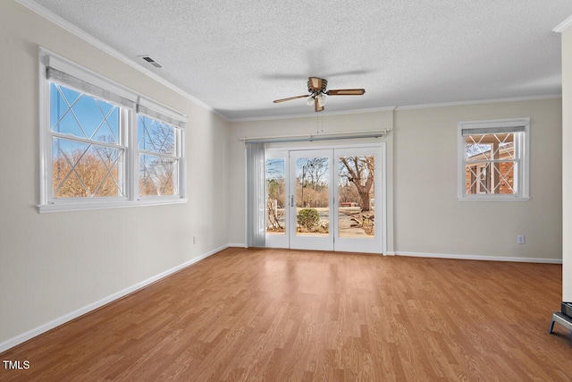 interior space with ornamental molding, plenty of natural light, and light wood-style flooring