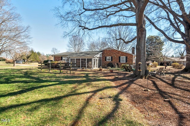 back of property featuring a yard and brick siding