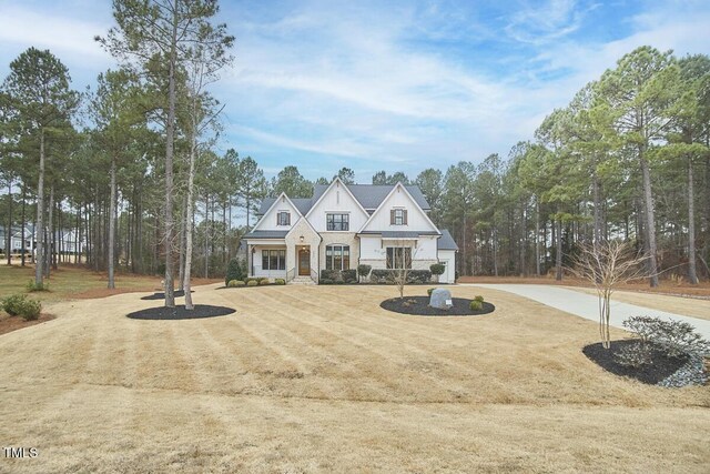 view of front of house featuring a porch, a front yard, and dirt driveway