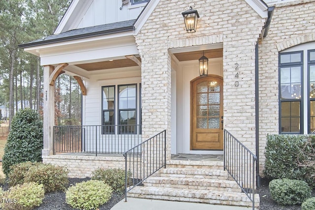 entrance to property with board and batten siding and brick siding