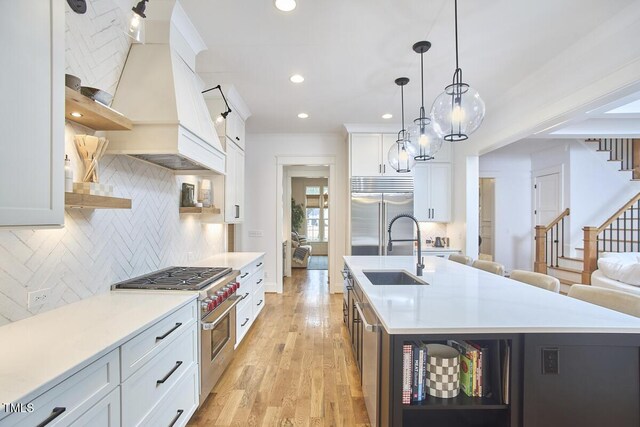 kitchen featuring a kitchen island with sink, white cabinetry, open shelves, and light countertops