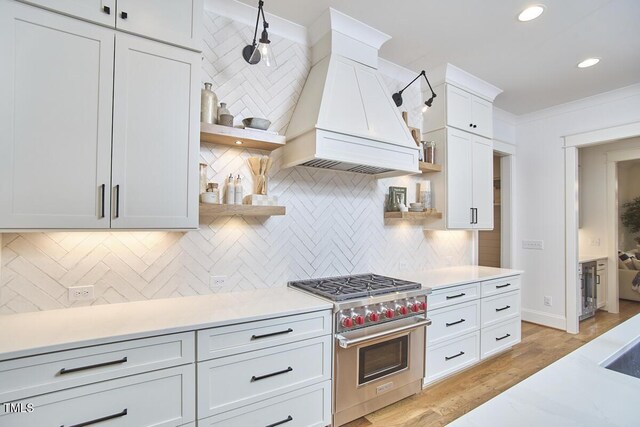 kitchen with premium stove, premium range hood, open shelves, and light countertops