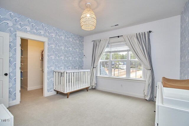 bedroom featuring light carpet, baseboards, visible vents, and wallpapered walls