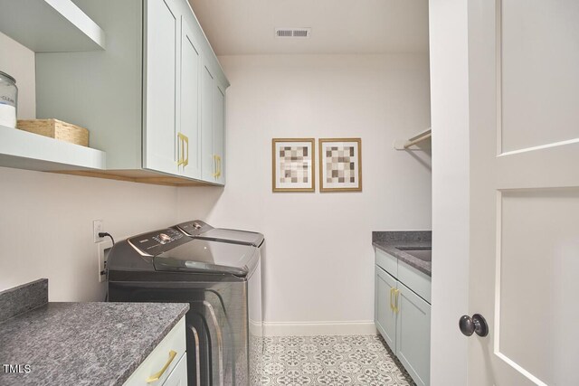 clothes washing area featuring cabinet space, baseboards, visible vents, and independent washer and dryer