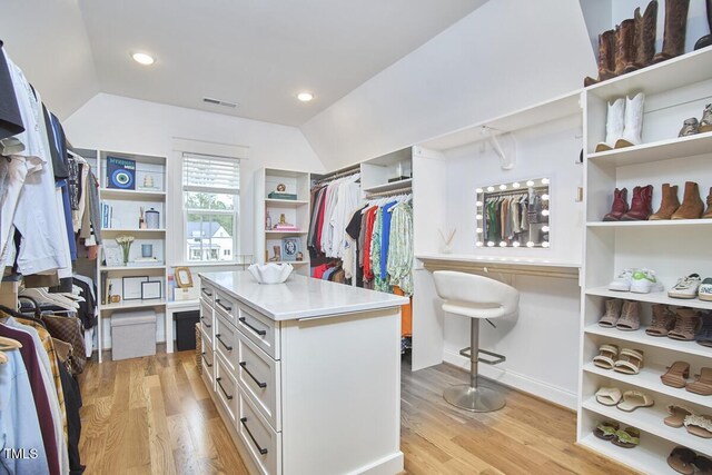 walk in closet with lofted ceiling, light wood finished floors, and visible vents