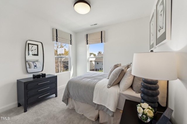 bedroom with light carpet, visible vents, and baseboards