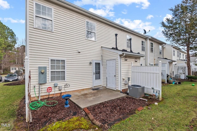 rear view of property with a yard, a patio area, and central air condition unit