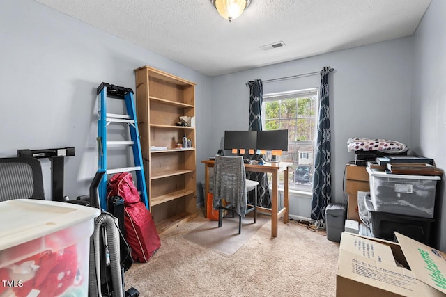 carpeted home office with a textured ceiling and visible vents