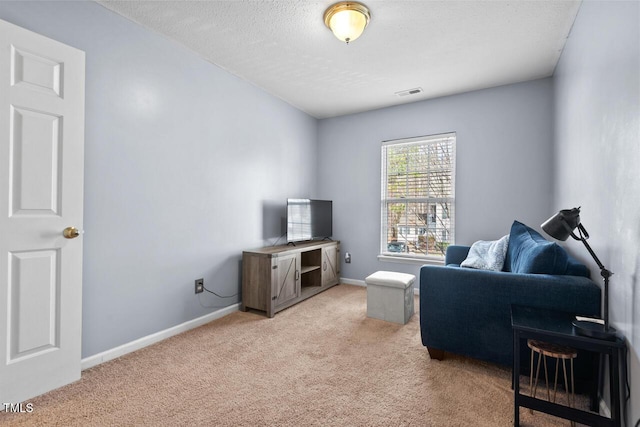 living area with light carpet, a textured ceiling, visible vents, and baseboards