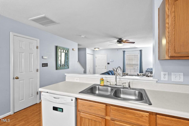 kitchen featuring a sink, visible vents, a ceiling fan, light countertops, and dishwasher