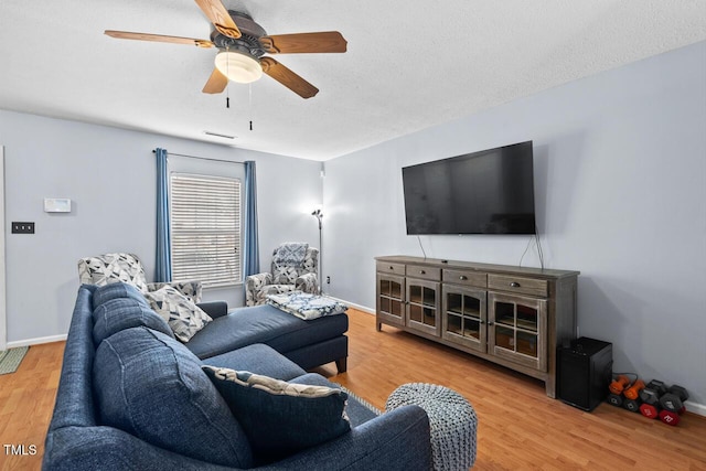 living area featuring light wood-type flooring, ceiling fan, and baseboards