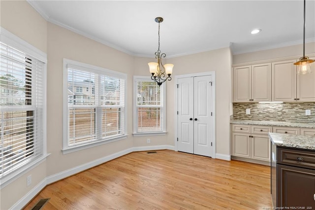 kitchen with decorative light fixtures, visible vents, backsplash, light wood-style floors, and baseboards