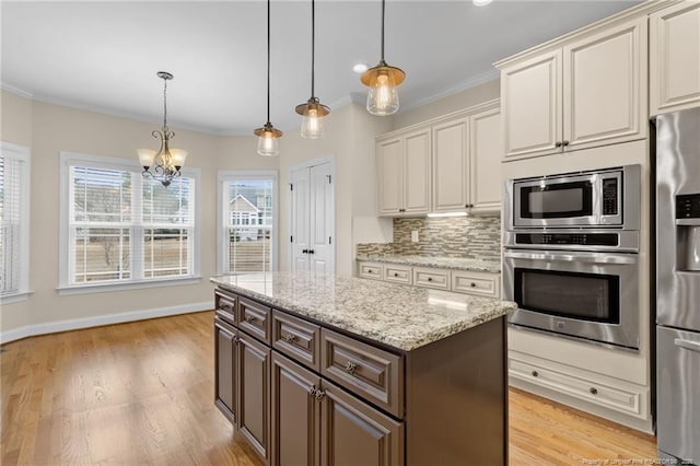 kitchen featuring tasteful backsplash, appliances with stainless steel finishes, hanging light fixtures, crown molding, and dark brown cabinets