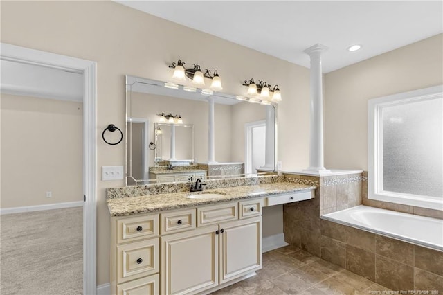 full bathroom with tile patterned floors, vanity, ornate columns, and a bath