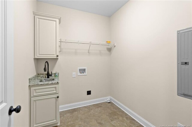 washroom featuring hookup for a washing machine, a sink, baseboards, cabinet space, and electric panel