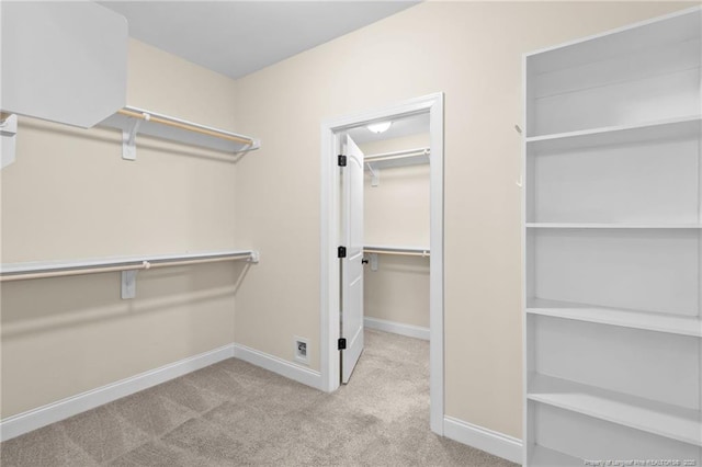 walk in closet with light colored carpet