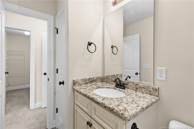 half bathroom featuring vanity and baseboards