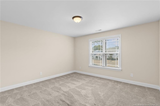 unfurnished room with light carpet, visible vents, and baseboards