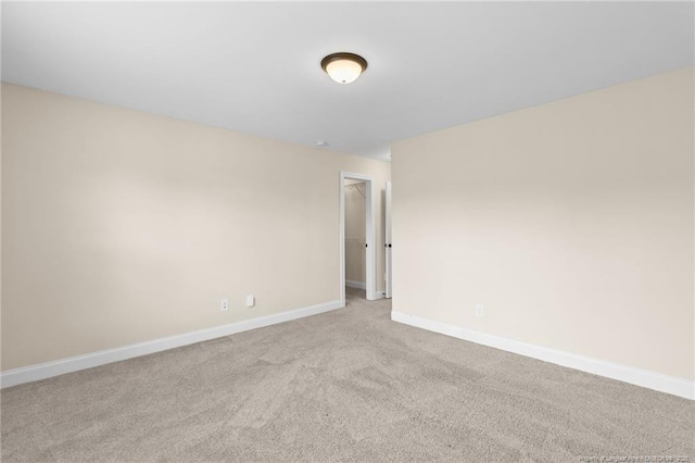 empty room with baseboards and light colored carpet