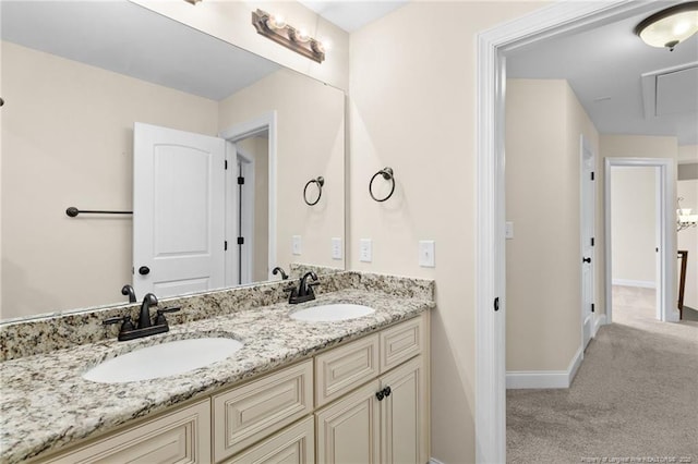 full bathroom with double vanity, a sink, and baseboards