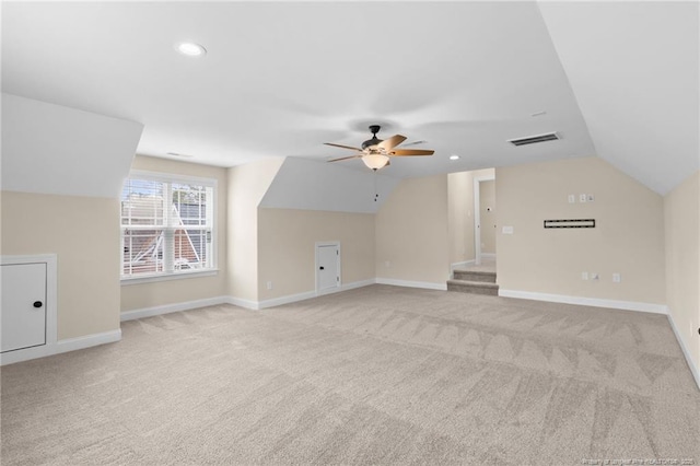 additional living space with light carpet, visible vents, baseboards, and vaulted ceiling