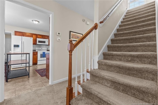 stairs featuring carpet floors and baseboards