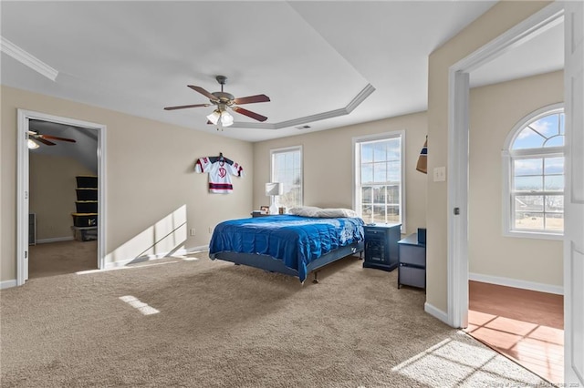 carpeted bedroom with a ceiling fan, a walk in closet, visible vents, and baseboards