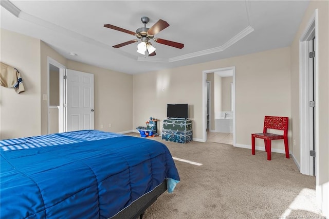 bedroom featuring ceiling fan, ensuite bath, carpet flooring, baseboards, and a raised ceiling