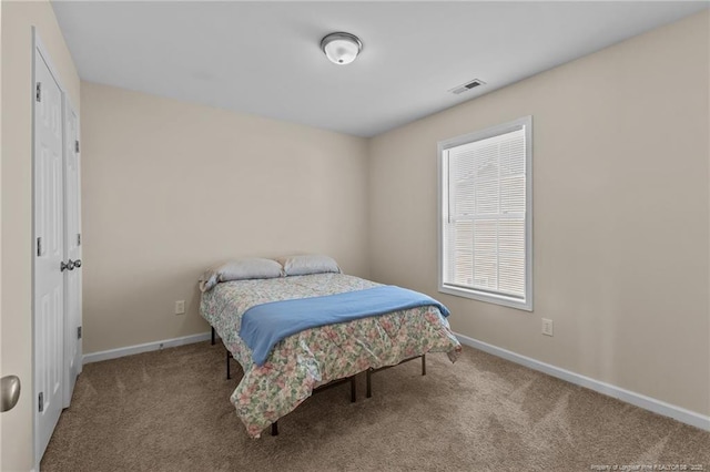 bedroom with carpet floors, visible vents, and baseboards