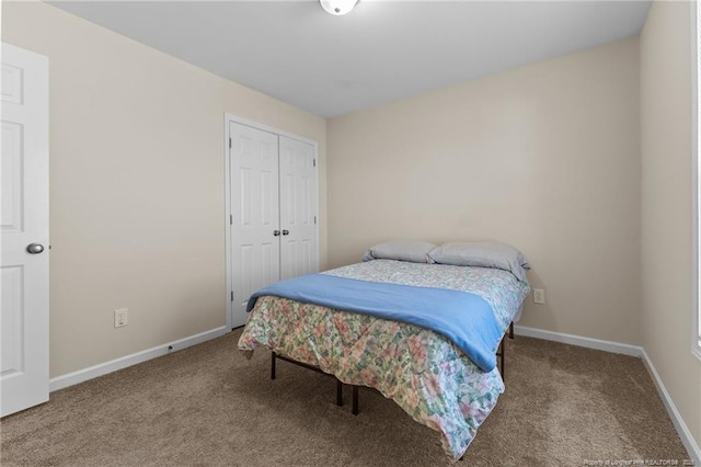 carpeted bedroom featuring a closet and baseboards