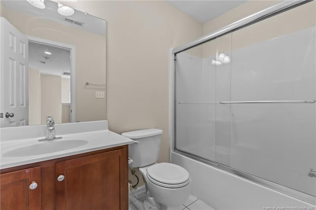 bathroom with toilet, shower / bath combination with glass door, visible vents, vanity, and tile patterned floors