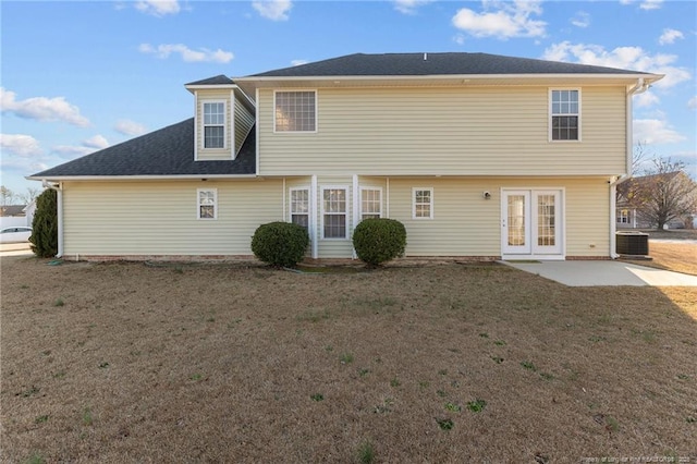 rear view of property with a patio area, a lawn, cooling unit, and french doors