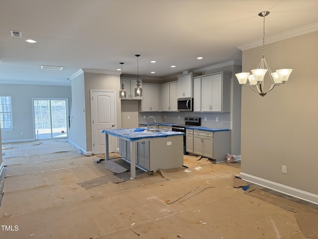 kitchen with a breakfast bar area, stainless steel appliances, baseboards, hanging light fixtures, and an island with sink