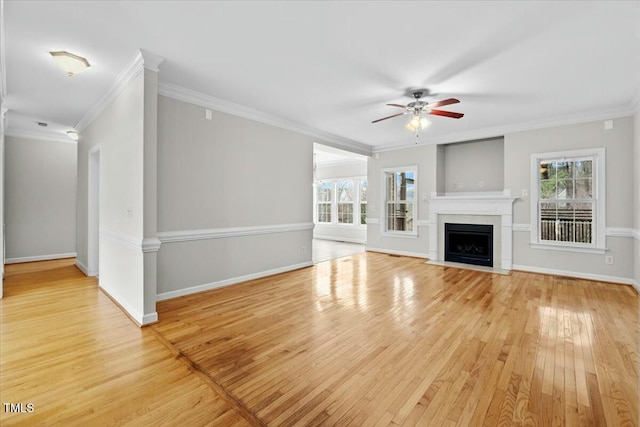 unfurnished living room with light wood-type flooring, a fireplace with flush hearth, and a wealth of natural light