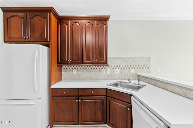 kitchen featuring white appliances, decorative backsplash, light countertops, and a sink