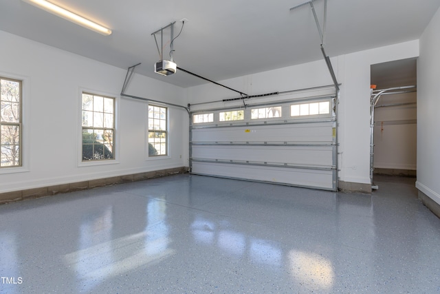 garage with a garage door opener and baseboards