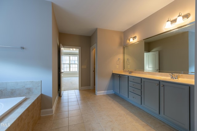 full bath featuring tile patterned floors, double vanity, a relaxing tiled tub, and a sink