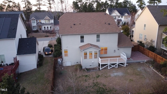 rear view of house featuring driveway, a fenced backyard, a residential view, a shingled roof, and crawl space