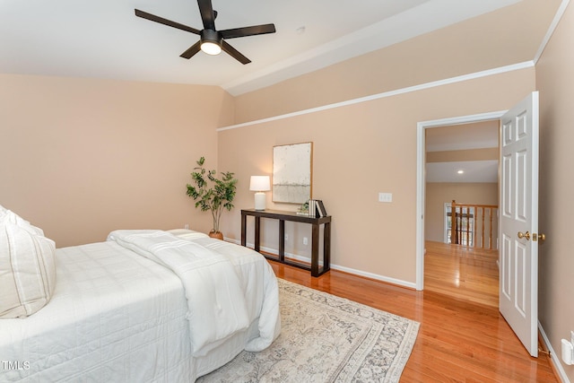 bedroom featuring lofted ceiling, light wood-style floors, ceiling fan, and baseboards