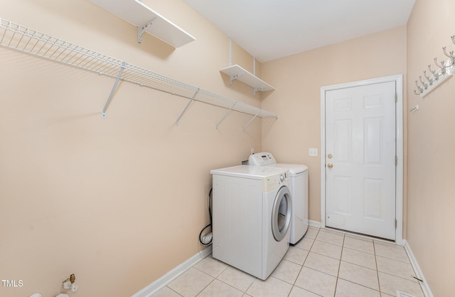 laundry area with laundry area, baseboards, separate washer and dryer, and light tile patterned flooring