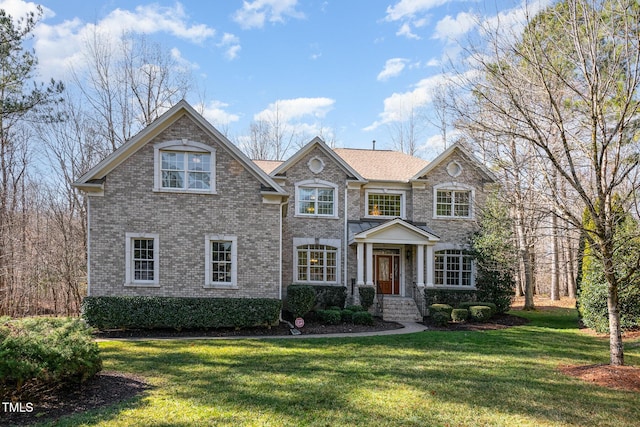 view of front of home with brick siding and a front yard